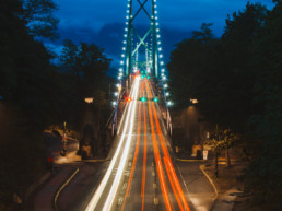 Vancouver's Lions Gate Bridge is lit up by the lights of passing cars.