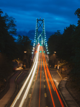 Vancouver's Lions Gate Bridge is lit up by the lights of passing cars.