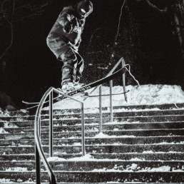 A freestyle skier attempts a rail in Kamloops BC. The photo is taken at night, lit by multiple flashes, giving the photo a punchy look.
