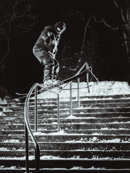 A freestyle skier attempts a rail in Kamloops BC. The photo is taken at night, lit by multiple flashes, giving the photo a punchy look.