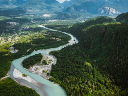Squamish River winds through the valley towards Howe Sound. The city of Squamish is visible in the background, as is the Stawamus Chief